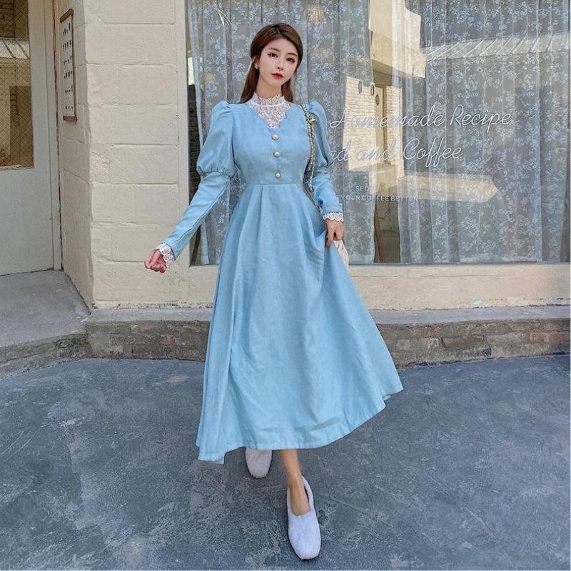woman in light blue dress with puff sleeves standing outside