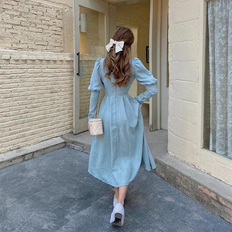 back view of woman in light blue dress with white bow in hair