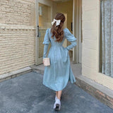 back view of woman in light blue dress with white bow in hair