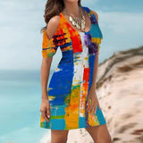 Woman wearing a colorful abstract print cold shoulder dress.