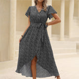 woman in black floral print wrap dress standing
