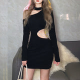 A woman wearing a black mini dress with a cut-out and pearl embellishment.