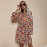 A woman models a yellow floral print dress with long bishop sleeves and a v-neck.