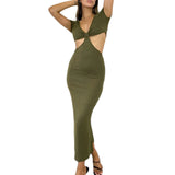 Woman wearing an olive green cut-out midi dress with short sleeves and black heels, standing.