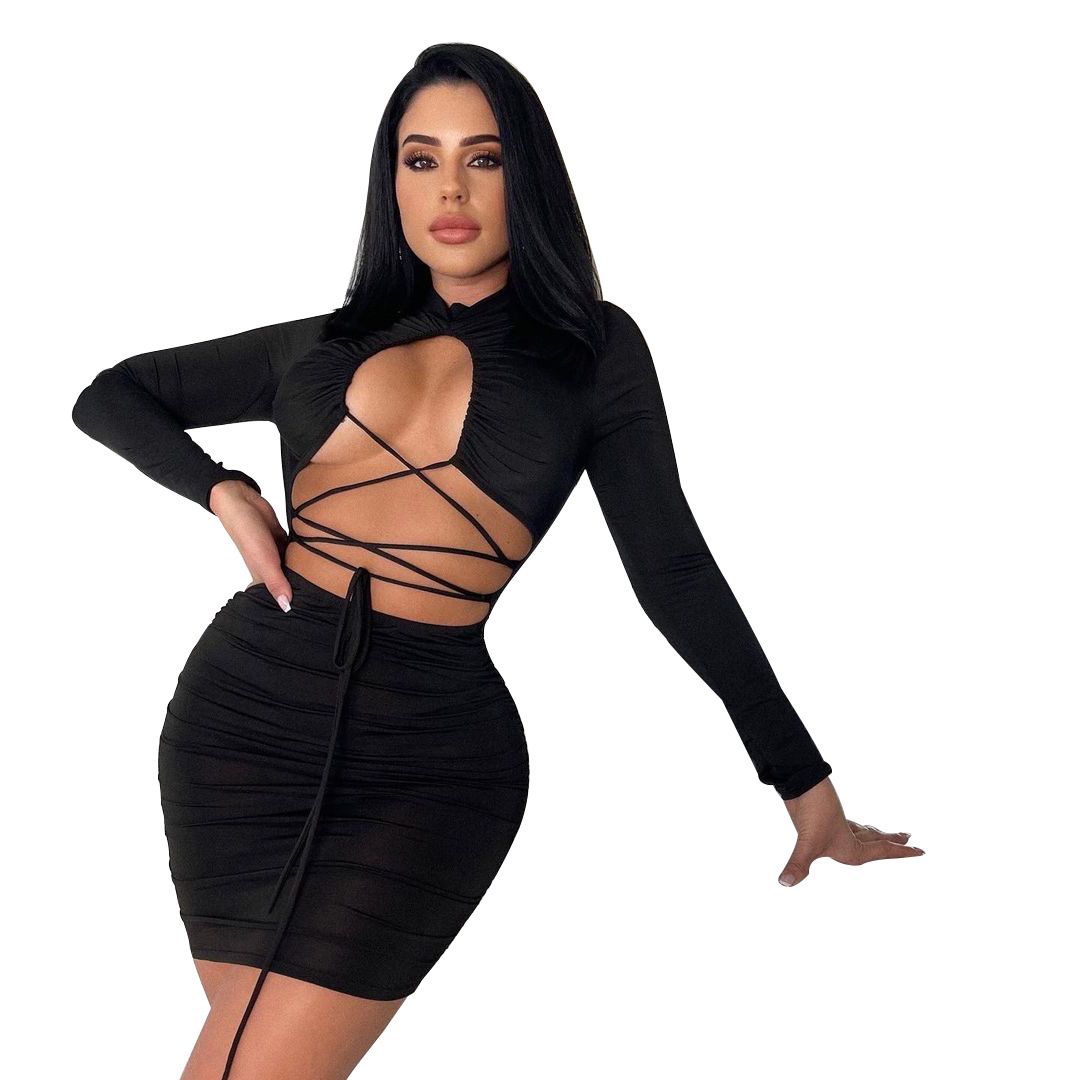Woman in a black long-sleeved, cut-out, lace-up, ruched mini dress against a white background.