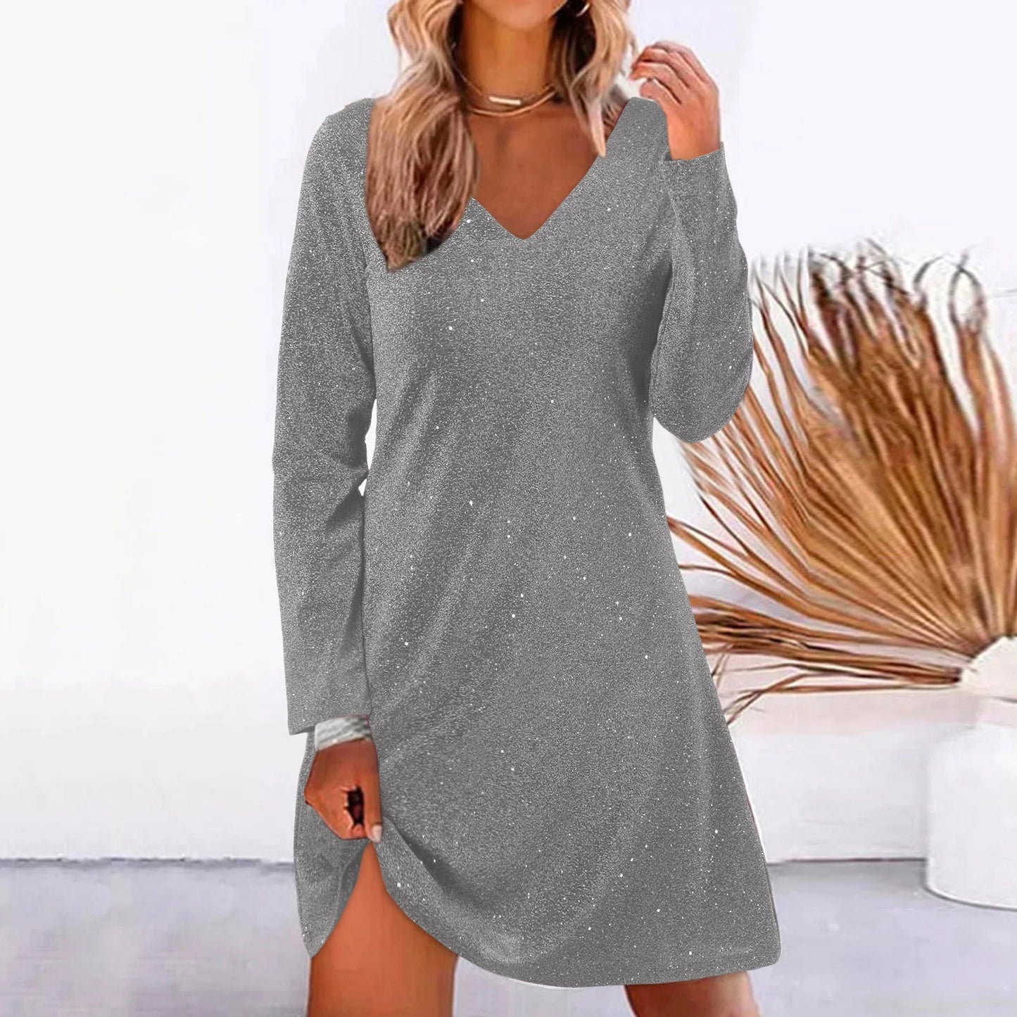 Woman wearing a silver sparkly long-sleeve v-neck dress.