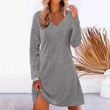 Woman wearing a silver sparkly long-sleeve v-neck dress.