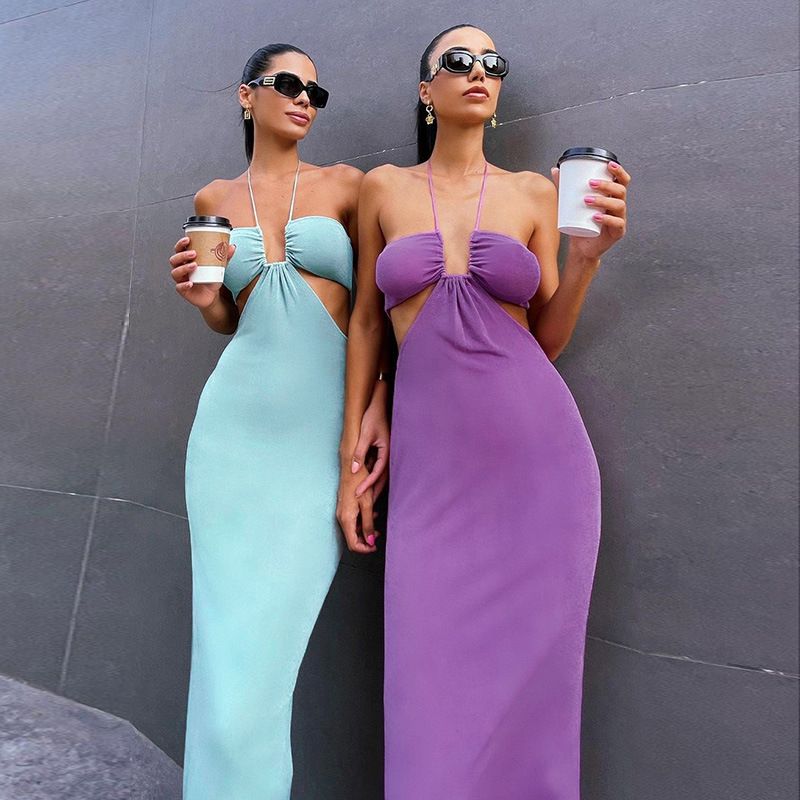 Two women in matching cutout dresses, one mint green and one purple