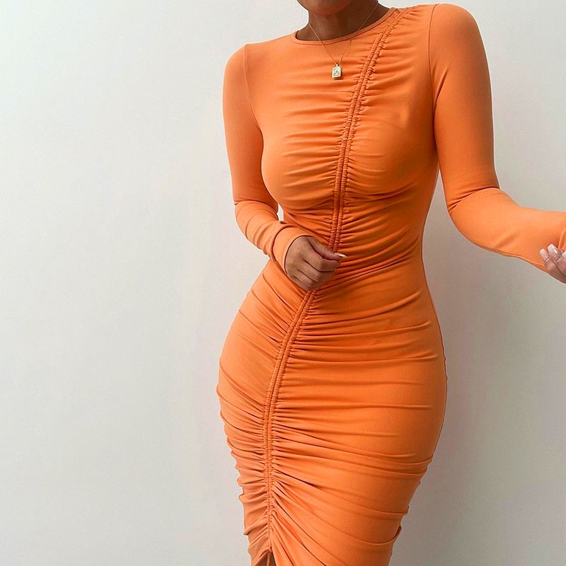 Close-up of a woman in an orange ruched long-sleeve dress