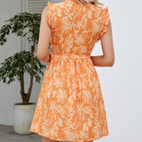 Back view of a woman in an orange floral print wrap dress