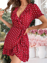 Side view of a woman in a red polka dot wrap dress