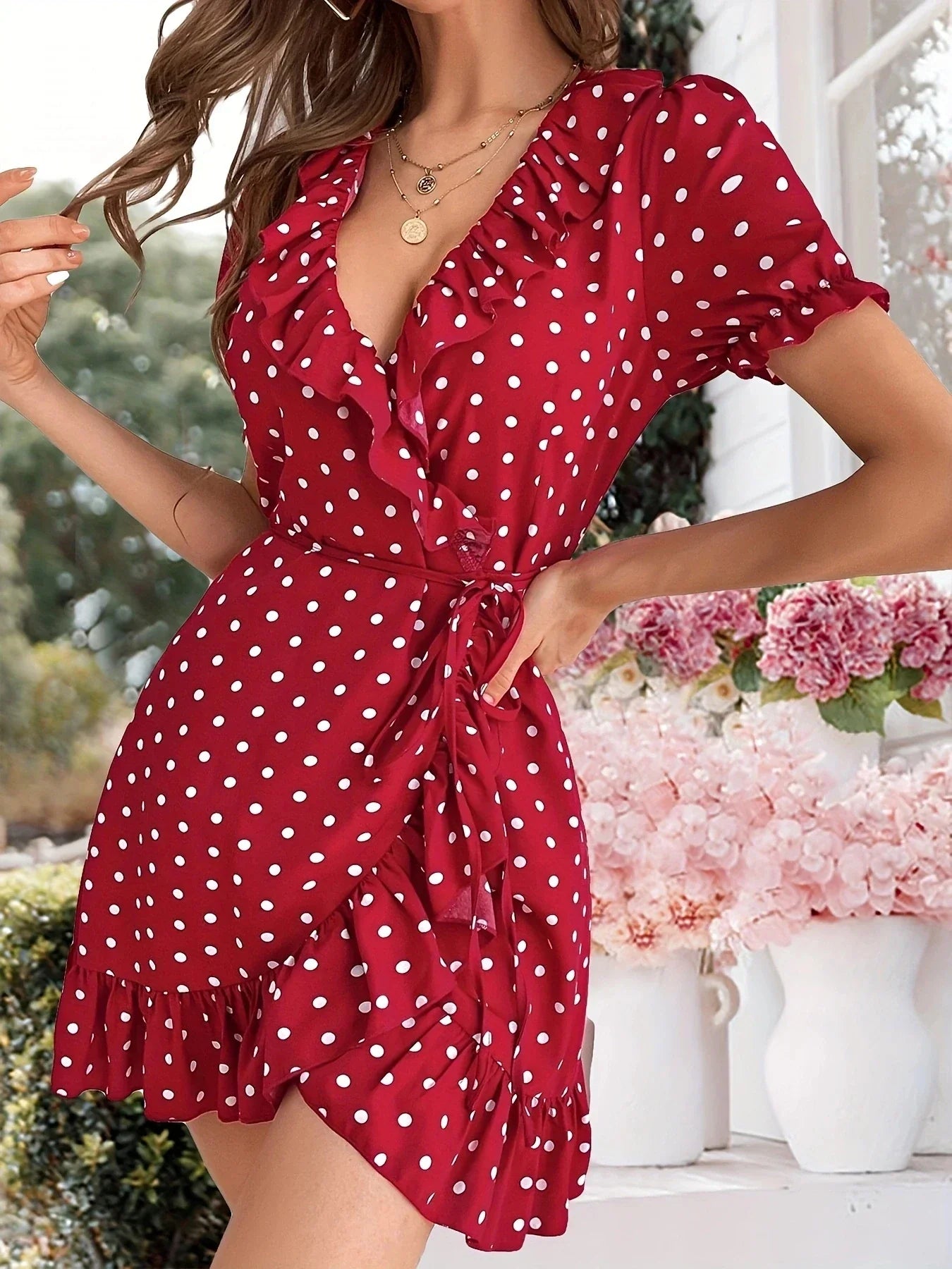 Side view of a woman in a red polka dot wrap dress