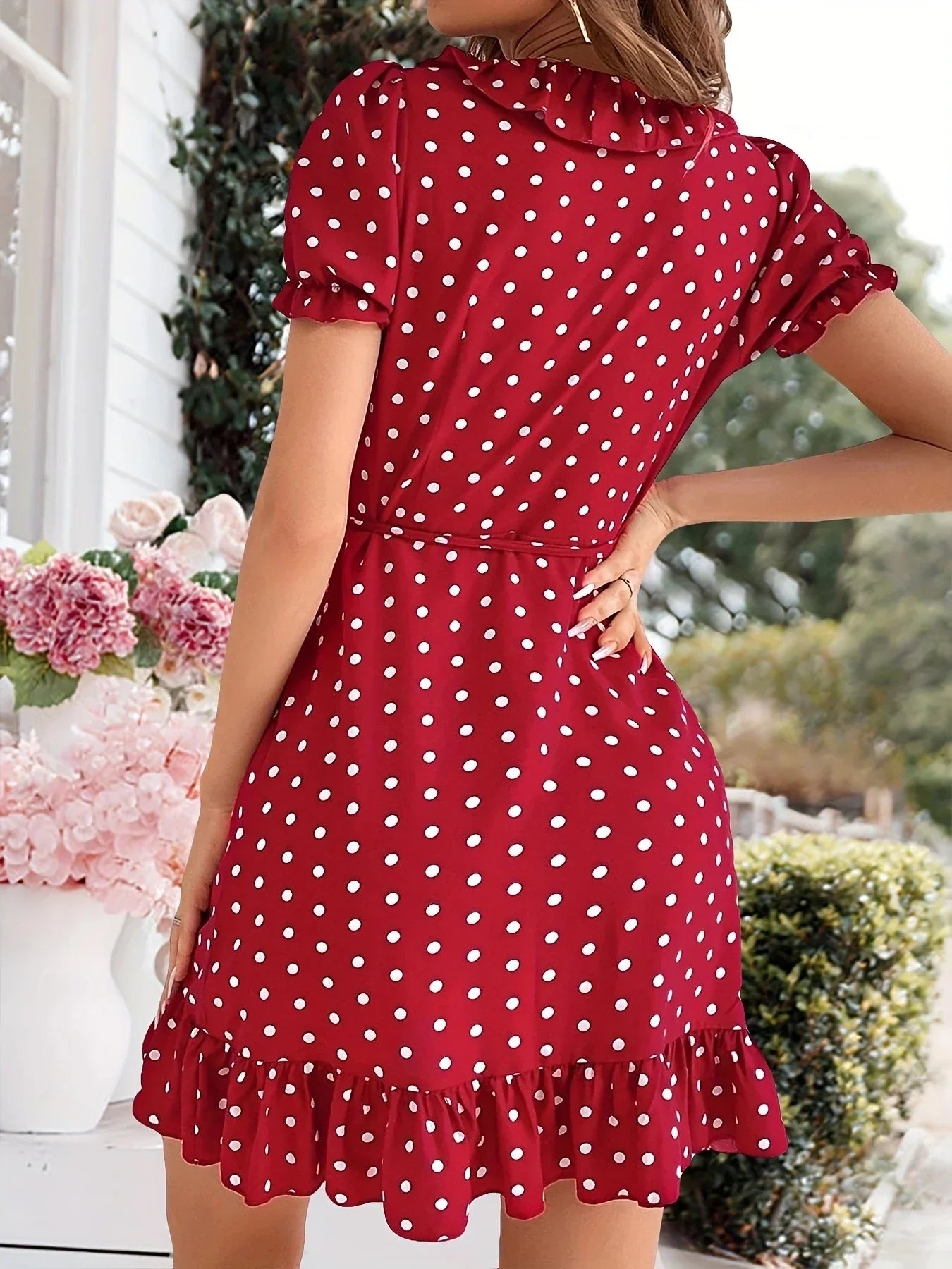 Back view of a woman in a red polka dot wrap dress