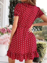 Back view of a woman in a red polka dot wrap dress