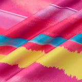 Close-up of the fabric of a pink, yellow, and blue striped dress, showing the texture and print.