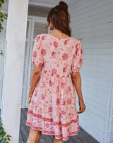 Back view of a woman wearing a pink floral print mini dress