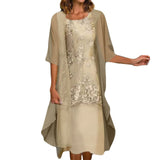 A woman wearing a beige floral lace dress with a sheer overlay.