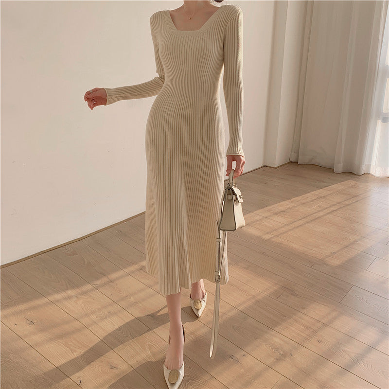 A woman wearing a beige ribbed knit midi dress with long sleeves and a square neckline, paired with white heels and a white handbag.