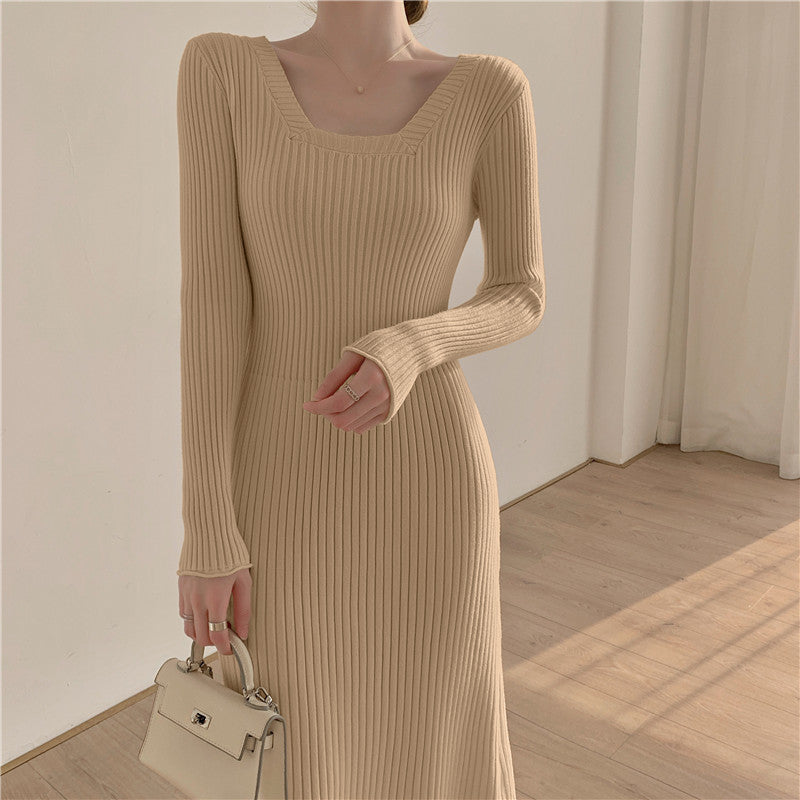 A woman wearing a light beige ribbed knit midi dress with long sleeves and a square neckline.