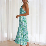 Woman wearing a green and blue floral one-shoulder midi dress from the side