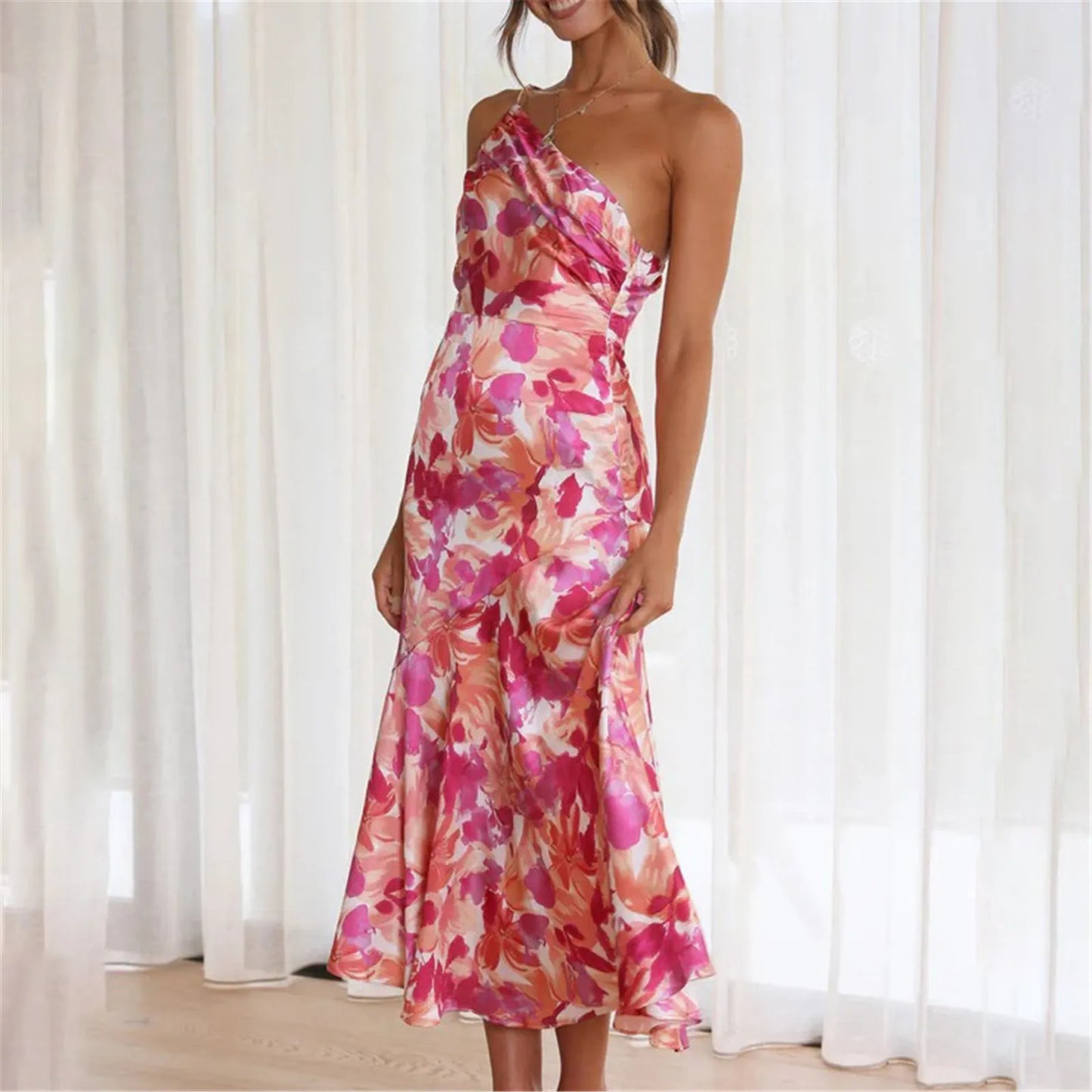 Woman wearing a pink floral one-shoulder midi dress smiling