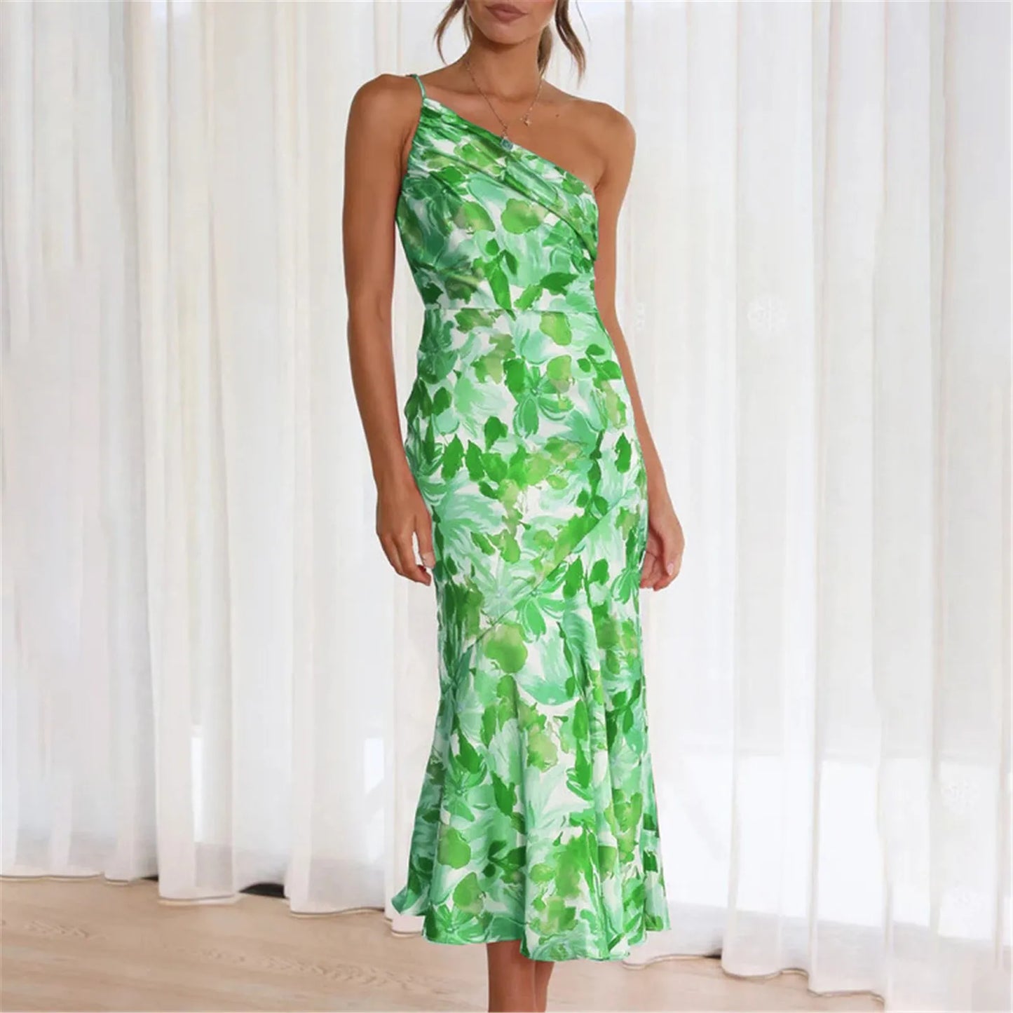 Woman wearing a green floral one-shoulder midi dress