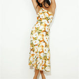 Woman wearing a yellow and white floral one-shoulder midi dress