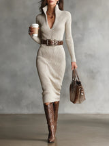 Woman in a cream ribbed knit dress with a brown belt and cowboy boots holding a coffee cup and a handbag