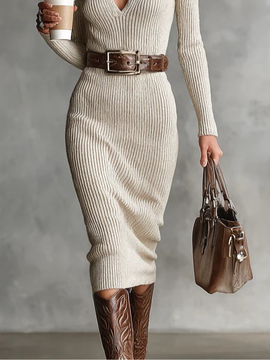 Woman in a cream ribbed knit dress, brown belt, and cowboy boots, holding a coffee cup and handbag