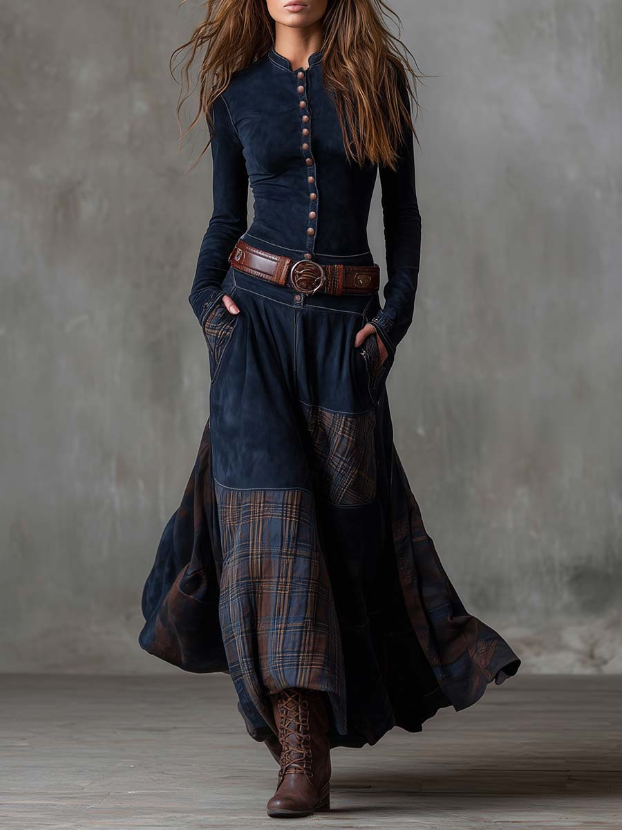 Woman wearing a long navy blue dress with plaid accents and a brown belt.