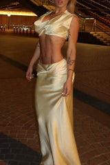Full body shot of a woman in a beige satin evening gown.