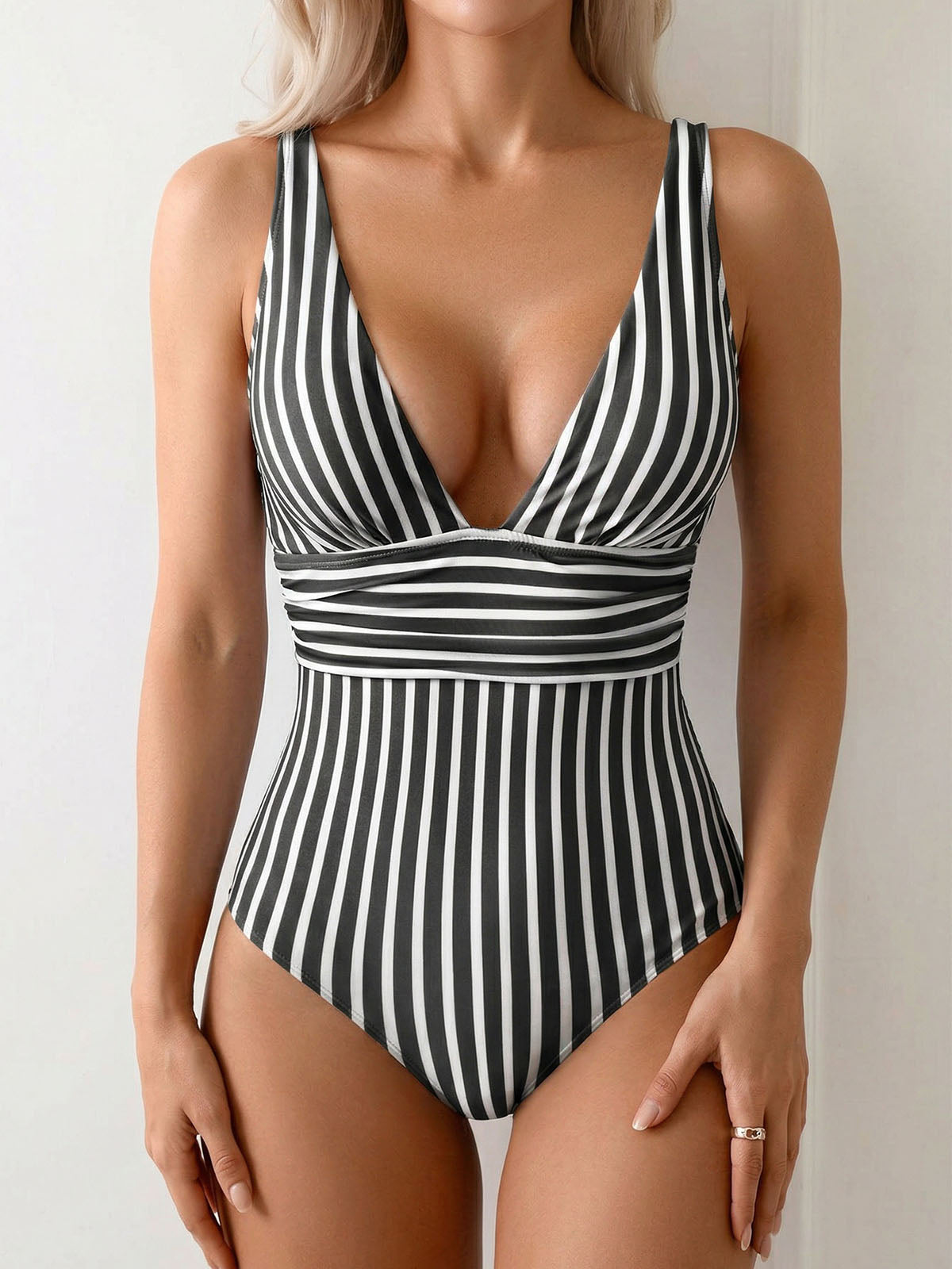 woman in a black and white striped one-piece swimsuit with a plunging neckline and elasticated waistband