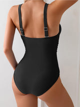 back view of a woman in a black one-piece swimsuit with adjustable straps