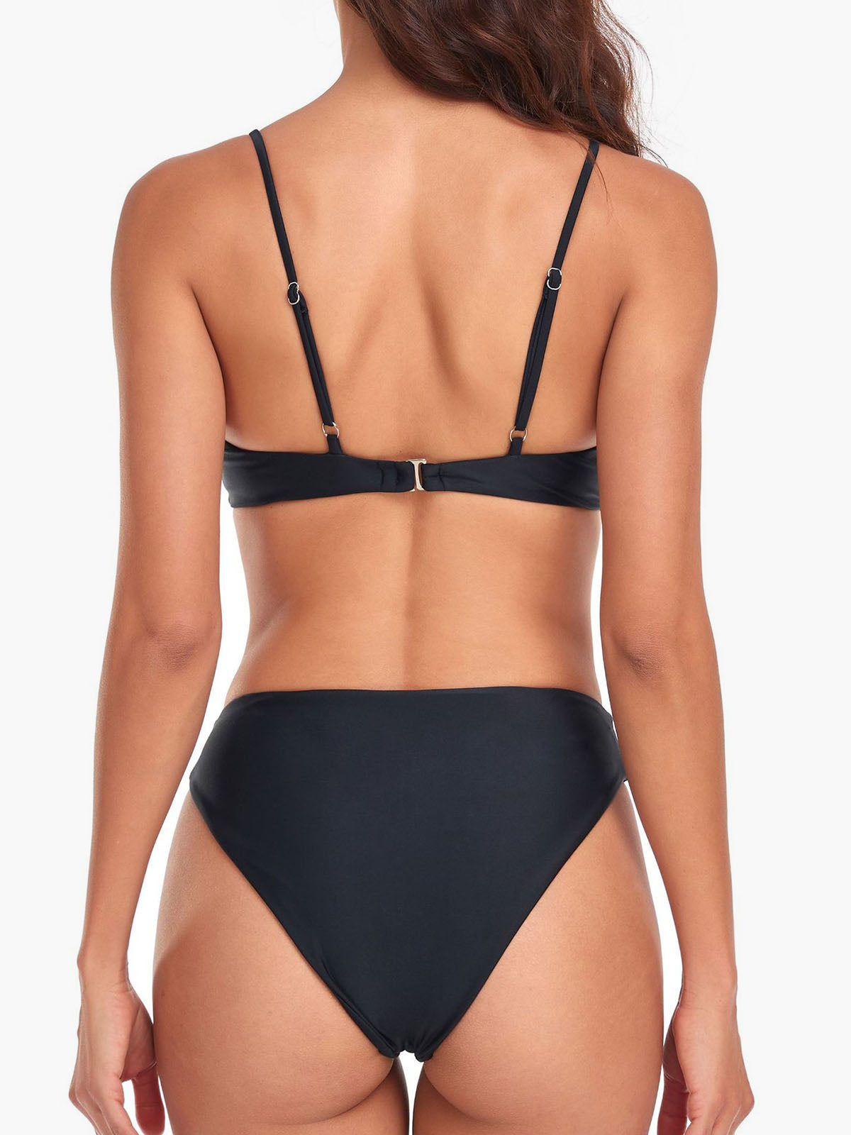 back view of a woman in a black bikini showing the strap detail and high-waisted bottoms