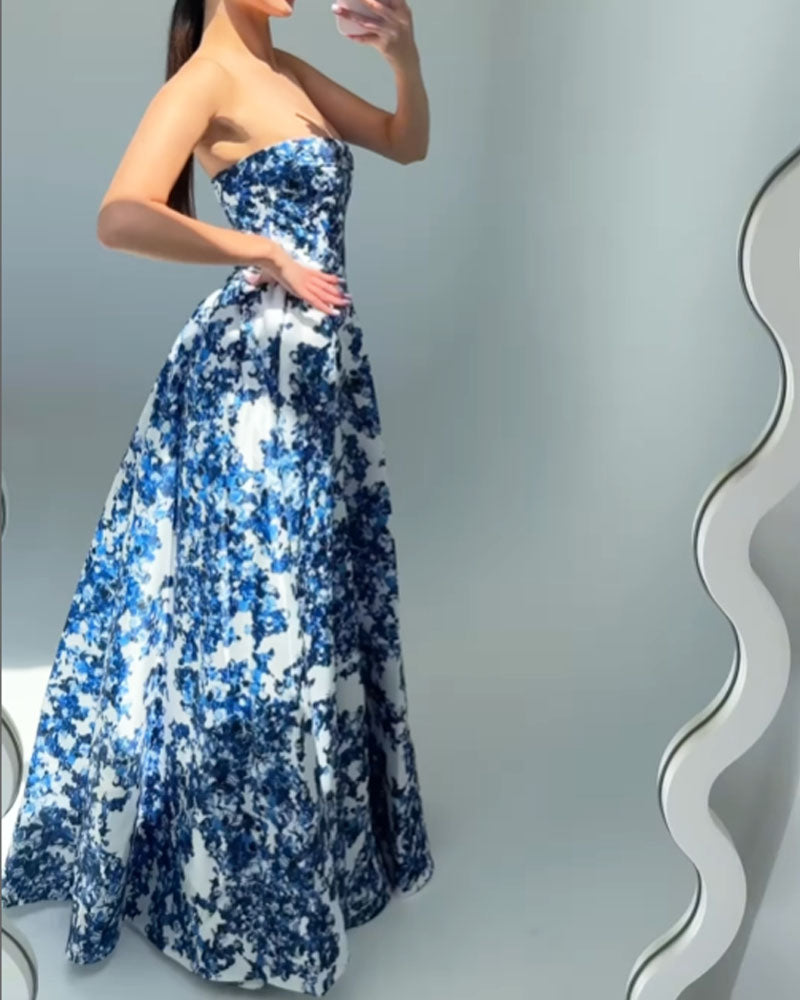 Woman taking a mirror selfie in a strapless blue and white floral print ball gown.