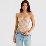 Woman wearing a beige lace corset top with light wash jeans, pulling at the waistband of her jeans