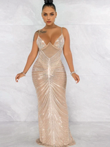 Woman in a sheer nude, floor-length gown with intricate silver beading arranged in vertical lines and intricate patterns on the bodice.