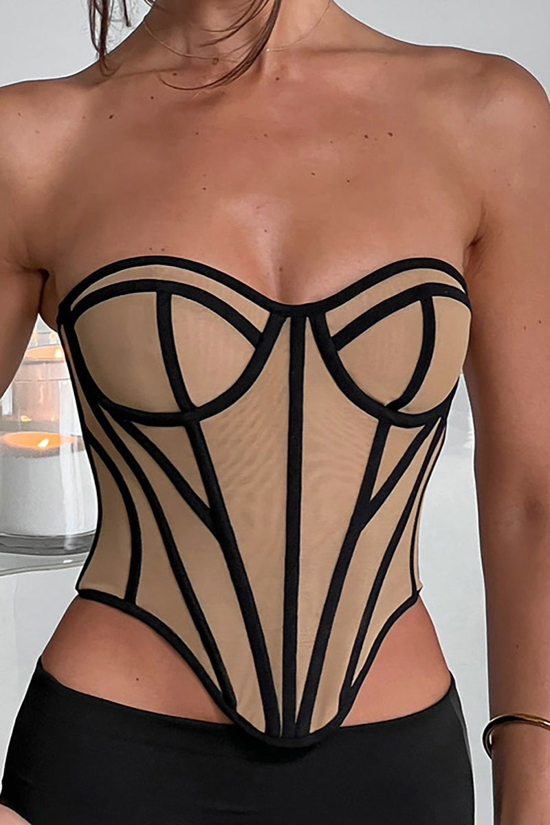 A woman wearing a tan and black strapless corset with a sweetheart neckline and geometric paneling.