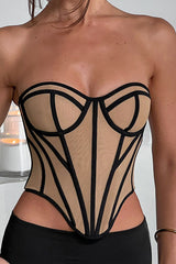 A woman wearing a tan and black strapless corset with a sweetheart neckline and geometric paneling.