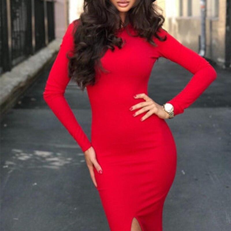 Woman in a red long-sleeved midi dress with a high slit, posing with hands on hips.