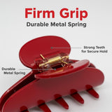 A close-up of a red claw clip showing its metal spring and teeth.