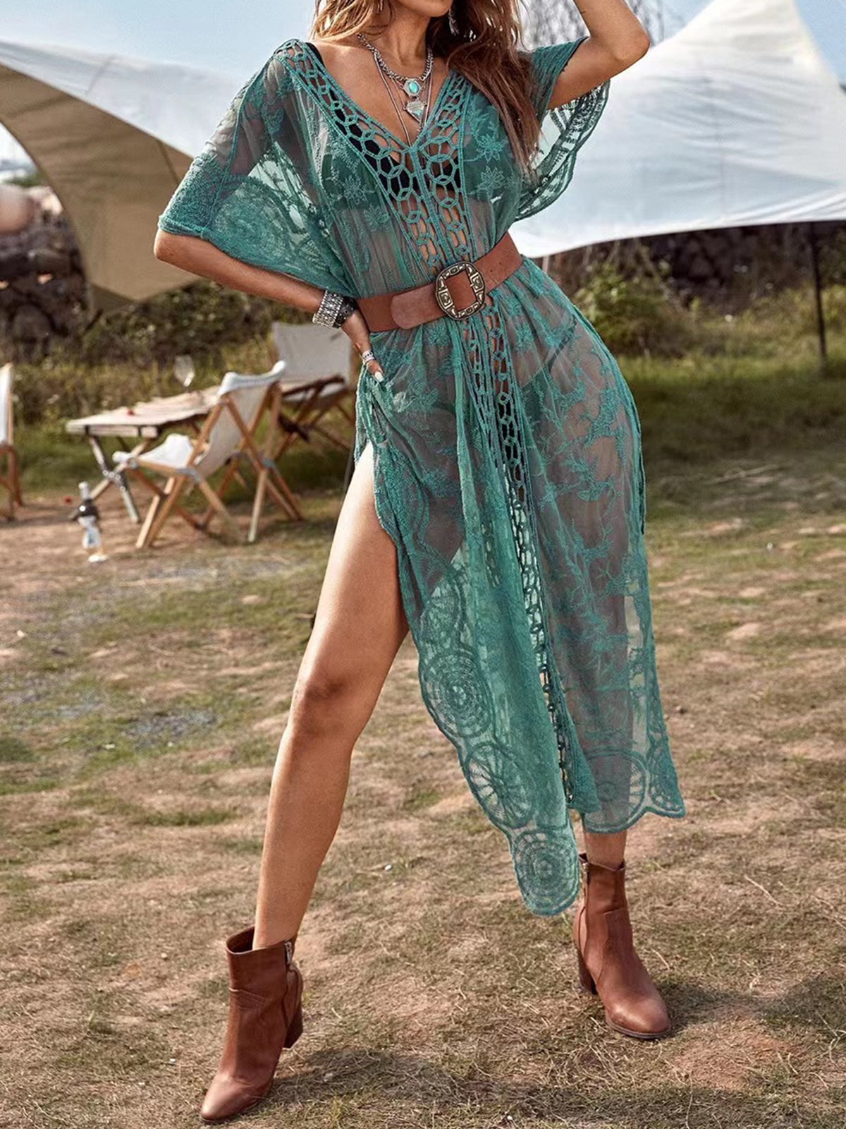Woman in a teal lace dress with a belt and boots