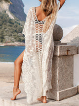 Back view of a woman in a white lace cover-up on a beach