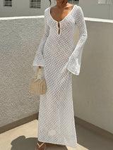 Woman wearing a white crochet knit maxi dress with bell sleeves and a deep V-neck.