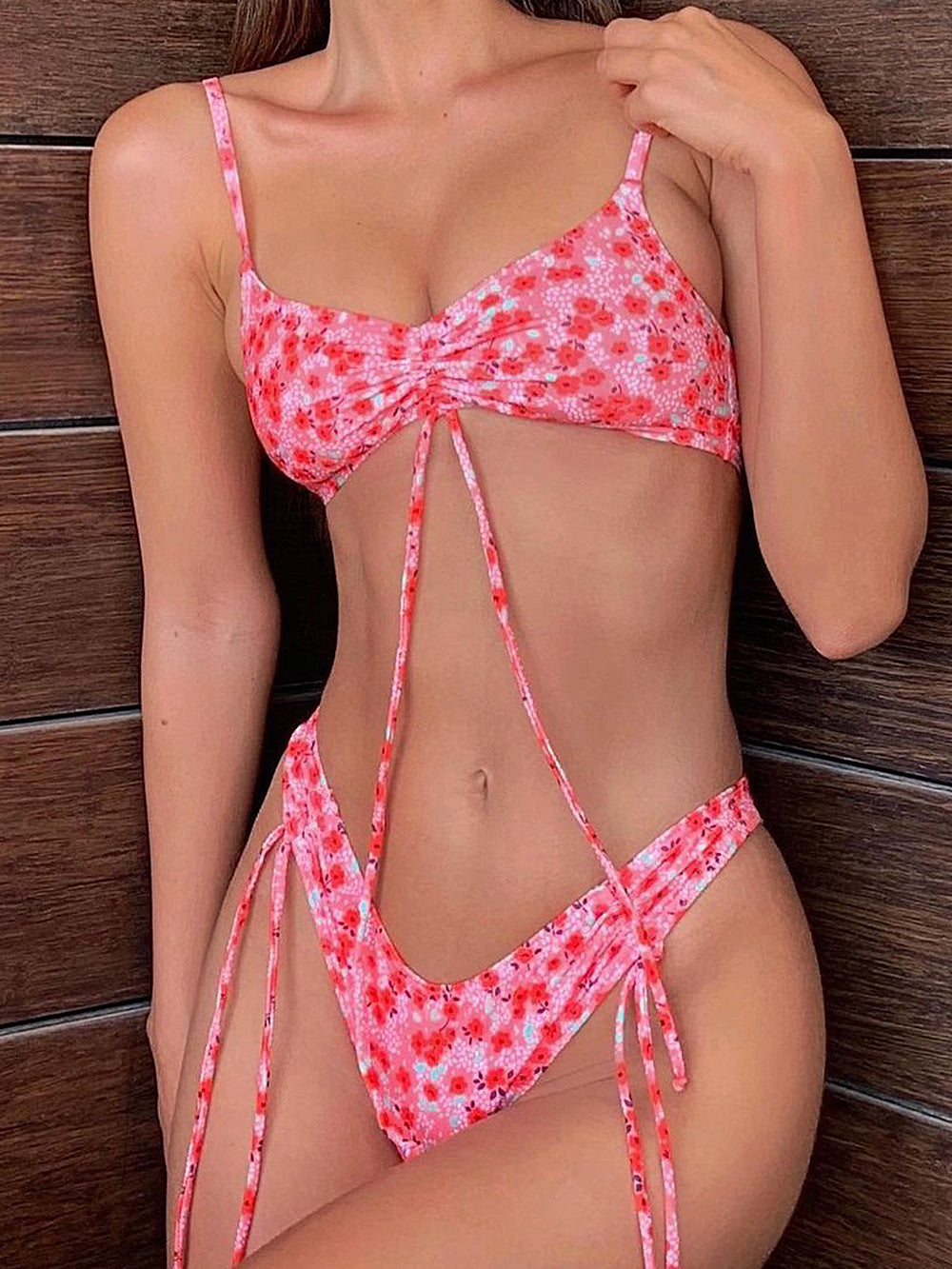 Woman in a pink floral bikini with ruched top and tie details
