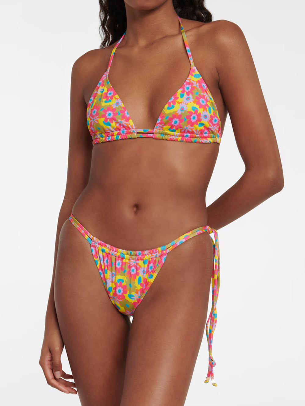 Front view of a woman wearing a pink and yellow floral print bikini with blue and green accents.