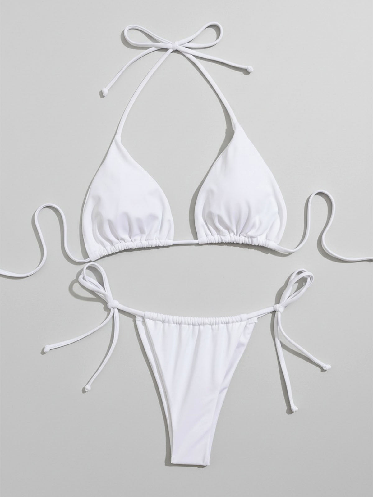White bikini top and bottom laid flat