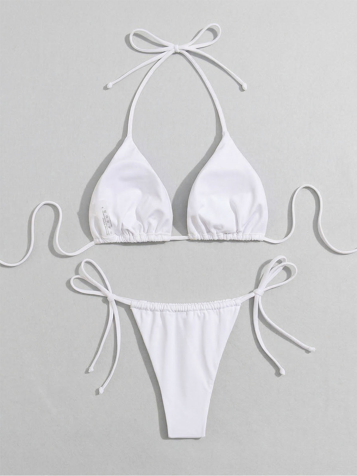 White bikini top and bottom laid flat with label detail