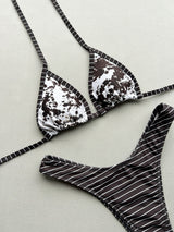 Close-up of a brown and white abstract print bikini top with striped ties