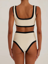 Back view of a woman wearing a cream and black ribbed bikini with high-waisted bottoms and a scoop neck top